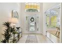 Bright and inviting foyer with tile flooring, a decorative front door, and high ceilings at 10203 Shadow Branch Dr, Tampa, FL 33647