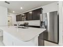 Well-equipped kitchen with stainless steel appliances, dark cabinetry, and a spacious center island at 10426 Cross River Trl, Parrish, FL 34219