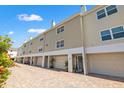Charming two-story condo exterior with attached garage and well-maintained brick paved drive and flowering plants at 1109 Pinellas Bayway S # 306, Tierra Verde, FL 33715