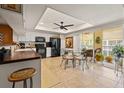 Bright kitchen with tiled floors, white cabinetry, and black appliances, including breakfast nook and views to the lanai at 1109 Pinellas Bayway S # 306, Tierra Verde, FL 33715