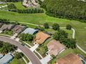 Picturesque aerial view showcasing the property's location near a golf course and a tranquil pond at 1115 Ashbourne Cir, Trinity, FL 34655