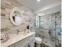 Modern bathroom featuring a glass-enclosed shower, stylish vanity, and chic wall tiles at 1548 Foxboro Dr, Palm Harbor, FL 34683