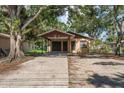 Full exterior shot showcasing the front of the home, carport, and surrounding greenery at 15623 Morgan St, Clearwater, FL 33760