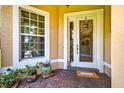 Inviting front entrance with a decorative wreath, potted plants, and a tiled porch at 15744 Crystal Waters Dr, Wimauma, FL 33598