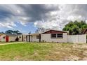 Charming home showcasing a white exterior, brown trim, and a lush green lawn at 3025 Palamore Dr, Holiday, FL 34691