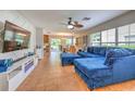 The open-concept living room features a cozy blue sectional, a ceiling fan, and plenty of natural light at 3110 Royal Tuscan Ln, Valrico, FL 33594