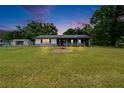 Charming single-story home features a covered porch, red front door and large front yard at 3212 Cork Rd, Plant City, FL 33565