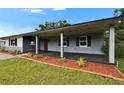 Charming single-story home features a covered porch, red front door, and landscaped front yard at 3212 Cork Rd, Plant City, FL 33565