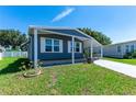 Quaint home with a carport, neatly landscaped lawn, and ample natural light streaming through the windows at 36435 Bonney Dr, Zephyrhills, FL 33541