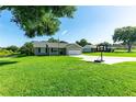 Inviting one-story home featuring lush green lawns, ample parking, and a cozy front porch area at 37113 Waldo Dr, Dade City, FL 33525