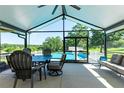 Relaxing screened-in porch with outdoor dining and seating, offering views of the sparkling pool and serene backyard at 37113 Waldo Dr, Dade City, FL 33525