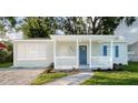 Charming home with a blue front door, white railing, and a walkway through the landscaped front yard at 3907 W Walnut St, Tampa, FL 33607
