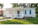 Charming home with a blue front door, white railing, and a walkway through the landscaped front yard at 3907 W Walnut St, Tampa, FL 33607