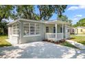 Attractive home featuring a stone driveway, a welcoming front porch, and manicured greenery at 3907 W Walnut St, Tampa, FL 33607