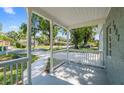 Inviting covered front porch with decorative railing that provides a view of the quiet neighborhood street at 3907 W Walnut St, Tampa, FL 33607