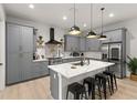 Modern kitchen featuring gray cabinetry, a quartz island with seating, and stainless steel appliances at 4913 N Nebraska Ave # 5, Tampa, FL 33603
