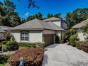 Charming home with a well-manicured lawn, a two-car garage, and a neutral colored stucco exterior at 5224 Fairway One Dr, Valrico, FL 33596