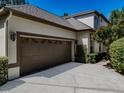 Two car garage with neutral colored door and stucco exterior, close up view at 5224 Fairway One Dr, Valrico, FL 33596