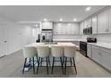 Bright kitchen with a large center island with seating, stainless steel appliances, and modern gray cabinets at 5336 Patano Loop, Palmetto, FL 34221
