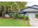 Charming home featuring an attached garage, beautiful landscaping, and a well-maintained lawn at 60 Birdsong Ct, Oldsmar, FL 34677