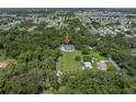 Aerial view of the property showcases its location nestled among mature trees at 7427 20Th St, Zephyrhills, FL 33540