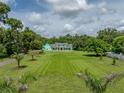 Expansive front yard of this estate home features lush landscaping and mature trees for added privacy at 7427 20Th St, Zephyrhills, FL 33540