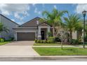 Inviting one-story home with a manicured lawn, brick driveway, and lovely tropical landscaping at 9672 Ivory Dr, Ruskin, FL 33573