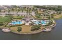 A stunning aerial view of the community pool and clubhouse overlooking the lake at 9814 Quadrangle Ct, Sun City Center, FL 33573