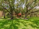 Multi-story condo building entrance with well-manicured lawn and mature trees offers an inviting curb appeal at 3078 Eastland Blvd # 205, Clearwater, FL 33761