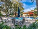 The community pool features a table with umbrella and multiple lounge chairs for relaxing poolside under blue skies at 3078 Eastland Blvd # 205, Clearwater, FL 33761