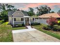 Attractive single-story home showcasing a spacious driveway, manicured lawn, and a charming covered front porch at 1005 45Th W St, Bradenton, FL 34209