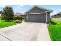 Spacious two-car garage of a single-story home with a wide concrete driveway at 10909 Kirkwall Port Dr, Wimauma, FL 33598