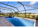 Relaxing screened-in pool area with an in-ground pool, spa and brick-paved deck at 1280 Hill Flower Dr, Brooksville, FL 34604