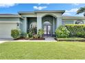 Charming front entrance with double doors, manicured garden, and inviting walkway at 12904 Prestwick Dr, Riverview, FL 33579