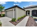 View of the home's side showing an attached two-car garage and arched entrance at 14047 Weddington Ter, Hudson, FL 34669