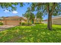 Inviting single-story home featuring a lush green lawn and a lovely garden in front at 14819 Redcliff Dr, Tampa, FL 33625