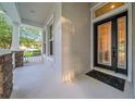Inviting front porch featuring stone accents and a decorative front door at 15405 Woodstar Landing Ct, Lithia, FL 33547