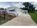 Mobile home with a ramp and a concrete driveway, providing ample parking space at 1710 7Th Sw St # 82, Ruskin, FL 33570
