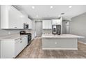Modern kitchen with white cabinets, an island, and stainless steel appliances, perfect for cooking at 17651 Bright Wheat Dr, Lithia, FL 33547