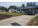 A modest one story home is shown from the street with a newly paved driveway and small front yard at 1922 Marvy Ave, Tampa, FL 33612