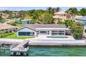 Scenic waterfront home with a dock, poolside patio, lush lawn, and picturesque bay view at 2002 Carolina Ne Cir, St Petersburg, FL 33703