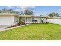 Attractive gray house with a brick path leading to the front porch, with a lush green lawn at 2452 Bayshore Blvd, Dunedin, FL 34698