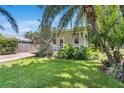 Charming home exterior features lush landscaping, a brick driveway, and a quaint front porch at 3220 W San Pedro St, Tampa, FL 33629