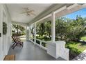 Inviting front porch with a ceiling fan, comfortable seating, and a view of the beautifully landscaped yard at 3220 W San Pedro St, Tampa, FL 33629