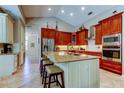Well-appointed kitchen featuring custom cabinets, an island with seating, and stainless steel appliances at 3353 Wedgewood Way, Tarpon Springs, FL 34688