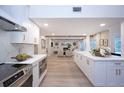 Open-concept kitchen with island, stainless appliances, flows into the living room with fireplace and wood beam accents at 35 Deerpath Dr, Oldsmar, FL 34677