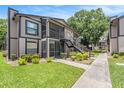 Exterior view of the condo building showing the stairs, patios and landscaping with grass and bushes at 4014 Dream Oak Pl # 202, Tampa, FL 33613