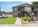 Exterior of the condo showing the stairs to the units and landscaping with grass and bushes at 4014 Dream Oak Pl # 202, Tampa, FL 33613