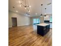 Open-concept living space with a kitchen island, hardwood floors, and modern lighting at 4639 Cabbage Palm Dr, Valrico, FL 33596