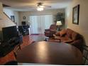Inviting living room with hardwood floors, a ceiling fan, a brown sofa, and sliding doors at 5100 Burchette Rd # 1304, Tampa, FL 33647